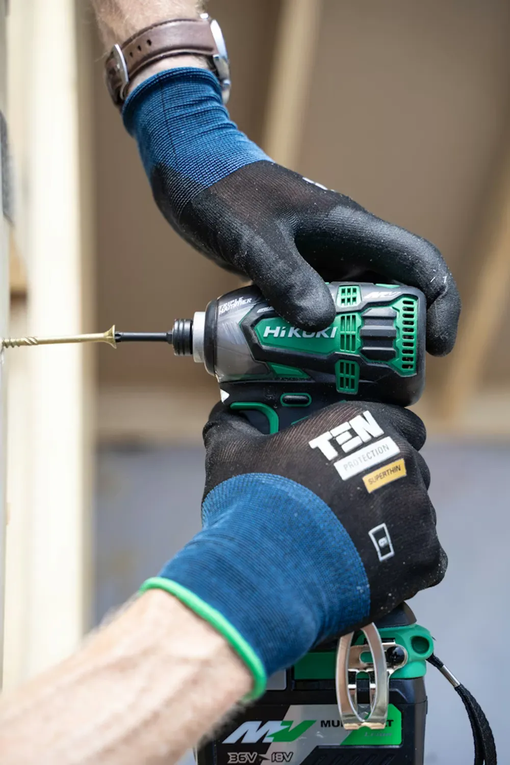 Byggare skruvar en skruv i en vägg