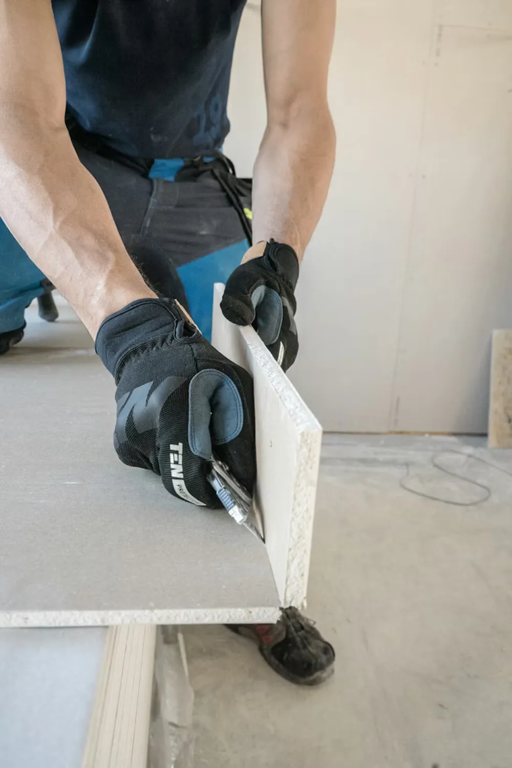 Arbetare skär en gipsplatta