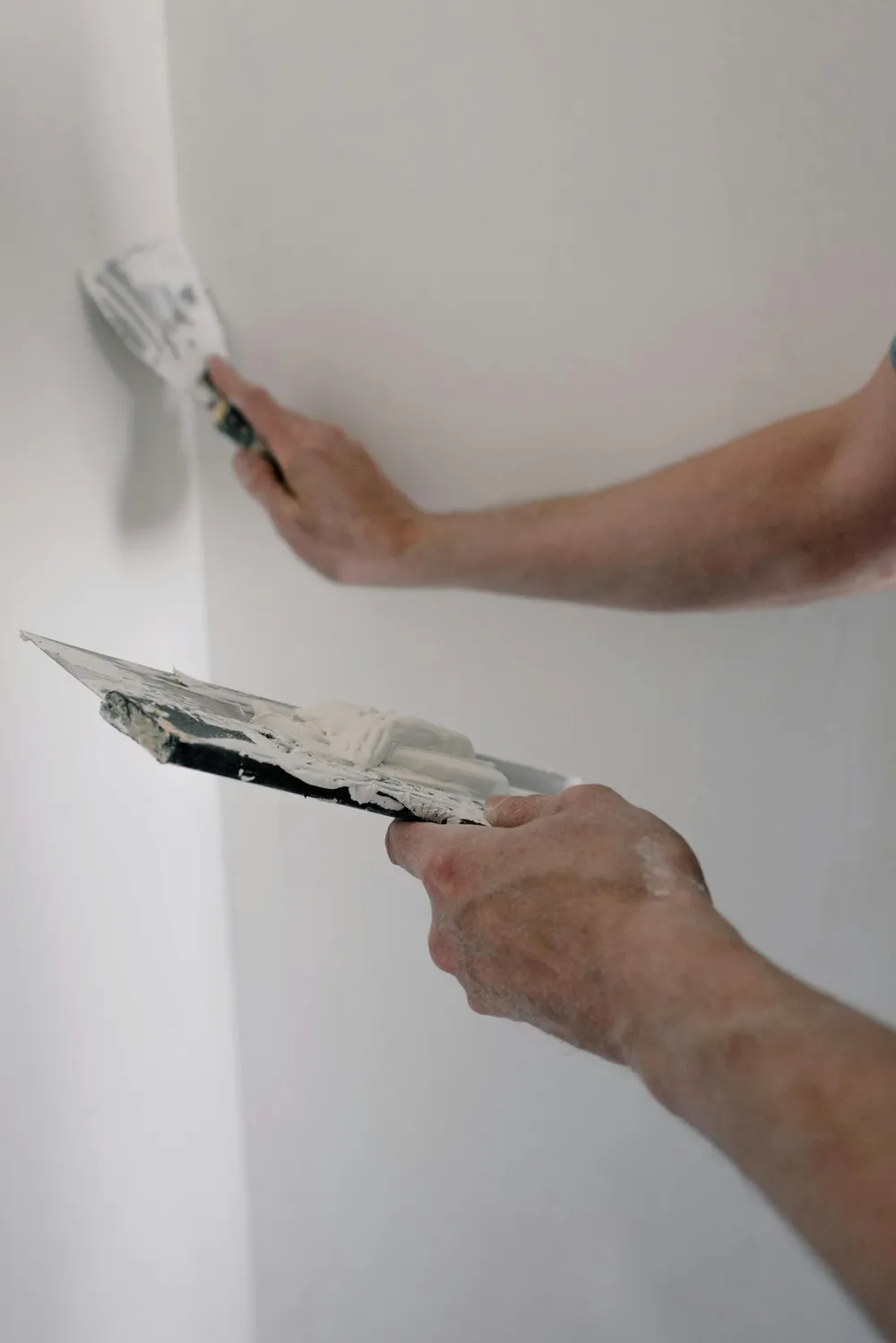 Arbetare spacklar en vägg